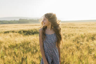 Fröhliches Mädchen mit zerzaustem Haar in einem Weizenfeld - AAZF00801