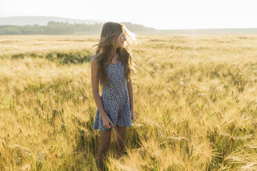 Lächelndes Mädchen mit langen Haaren in einem Weizenfeld - AAZF00802