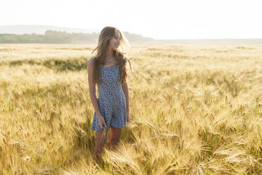 Smiling girl standing amidst wheat crop - AAZF00803