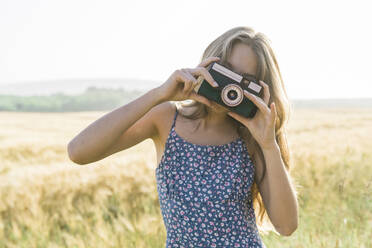 Mädchen fotografiert mit Kamera auf Feld - AAZF00831