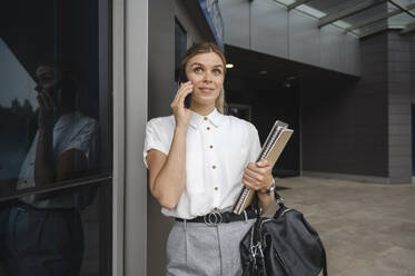Smiling businesswoman talking on smart phone - ALKF00411