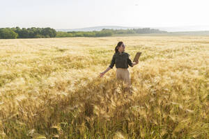 Agronom mit Tablet-PC im Feld stehend - AAZF00871