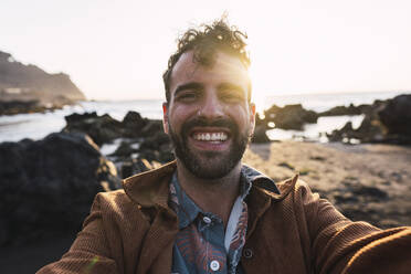Happy man taking selfie at sunset - PNAF05851