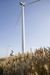Agronomist standing in front of wind turbines - EKGF00388