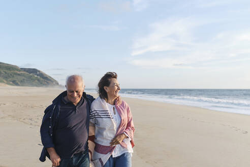 Glückliches älteres Paar beim Spaziergang am Strand - ASGF04084