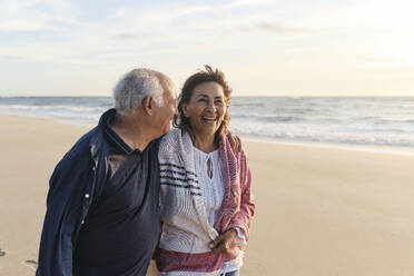Glückliche ältere Frau, die ihren Urlaub mit einem Mann am Strand genießt - ASGF04090