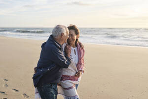 Glückliches älteres Paar hat Spaß am Strand - ASGF04092