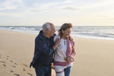 Happy senior couple together walking at beach - ASGF04094