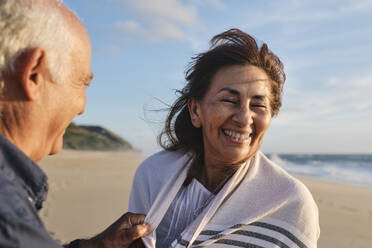 Happy senior woman and man having fun at beach on sunny day - ASGF04110