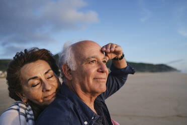 Smiling senior couple enjoying at beach - ASGF04218