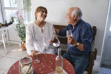 Happy senior woman talking with man sitting in cafe - ASGF04247