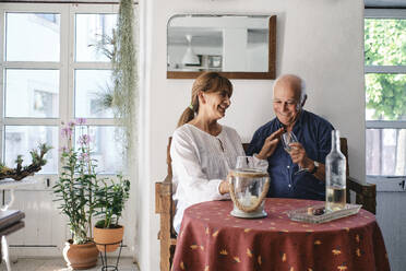 Glückliche ältere Frau und Mann sitzen am Tisch in einem Cafe - ASGF04251