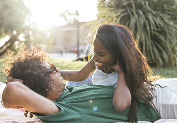 Lächelndes Paar verbringt seine Freizeit im Park an einem sonnigen Tag - PBTF00098