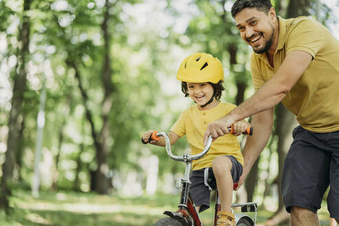 Vater und Sohn genießen das Radfahren im Park - ANAF01830