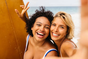 Surferinnen fangen ihre Unbekümmertheit und aufregenden Erlebnisse mit einem strahlenden Lächeln in einem lustigen Strand-Selfie ein - JLPSF30662