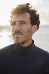 Thoughtful man wearing turtleneck sweater at beach - JOSEF20333