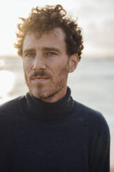 Mature man wearing turtleneck sweater at beach - JOSEF20334