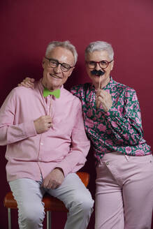 Happy senior couple posing with fake moustache and bowtie - RBF09125