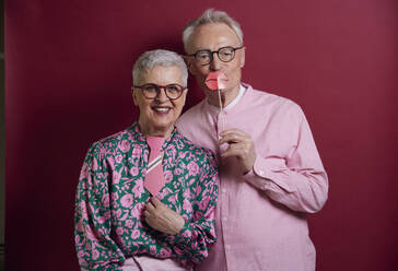 Happy senior couple posing with fake lips and tie - RBF09127