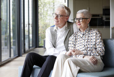 Senior couple sitting on couch at home - RBF09159