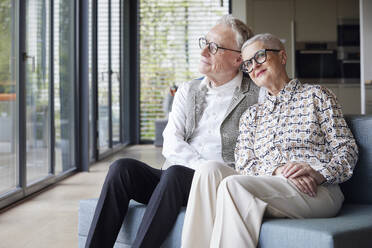 Senior couple sitting on couch at home - RBF09161