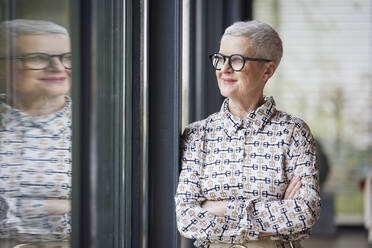 Senior woman at home looking out of window - RBF09165