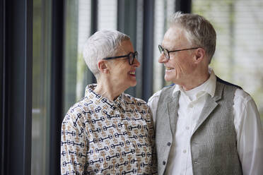 Glückliches älteres Ehepaar, das sich zu Hause gegenseitig ansieht - RBF09181