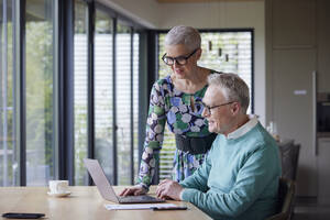 Älteres Paar benutzt Laptop am Tisch zu Hause - RBF09208