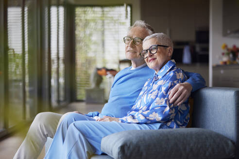 Älterer Mann umarmt Frau auf der Couch zu Hause - RBF09226