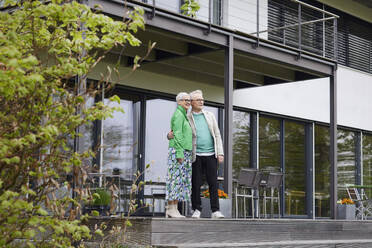 Senior couple standing in front of their home - RBF09247