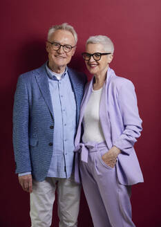 Portrait of confident senior couple against purple background - RBF09276