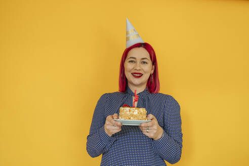 Lächelnde Frau mit gefärbten Haaren hält Geburtstagstorte - OSF01915