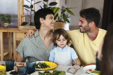 Lächelnde Eltern mit Sohn beim Mittagessen am Esstisch zu Hause - EBSF03678