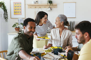 Glückliche Familie verbringt ihre Freizeit mit einem Mittagessen am Esstisch in der Küche - EBSF03695