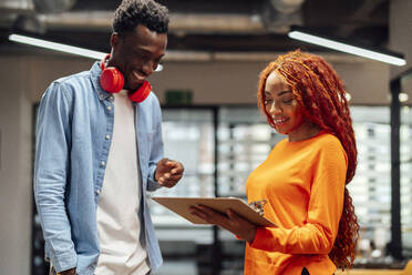 Happy businessman and businesswoman having discussion over document - PGF01592