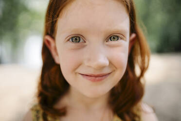 Smiling redhead girl in park - SSYF00184