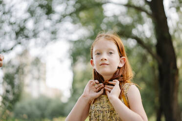 Contemplative girl touching hair in park - SSYF00185