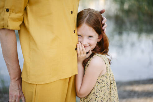 Lächelndes Mädchen steht in der Nähe der Mutter im Park - SSYF00186