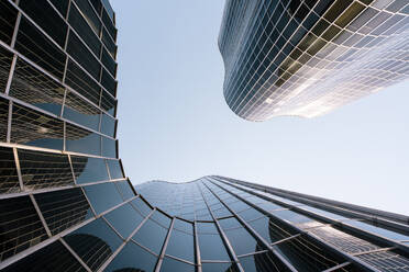 Spain, Catalonia, Barcelona, Directly below view of modern glass skyscraper - MMPF00796