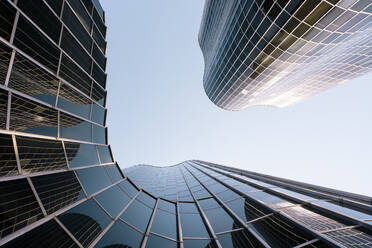 Spanien, Katalonien, Barcelona, Blick von unten auf einen modernen Glas-Wolkenkratzer - MMPF00796