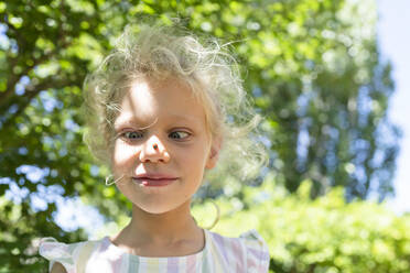 Smiling girl with ladybug on nose in park - SVKF01571