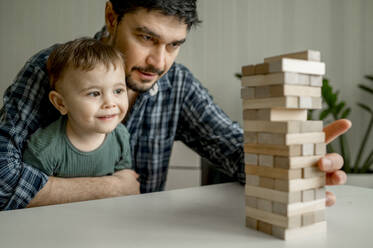 Mann spielt Jenga mit Sohn zu Hause - ANAF01859