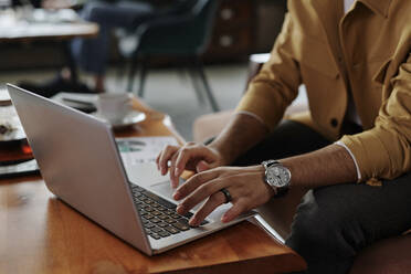 Geschäftsmann arbeitet an einem Laptop in einem Café - DSHF00914