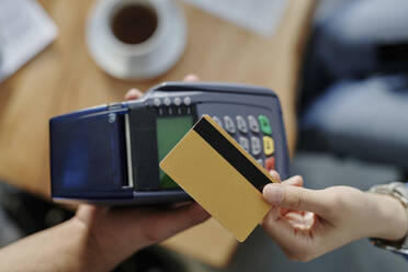 Hand of woman paying through credit card at cafe - DSHF00923