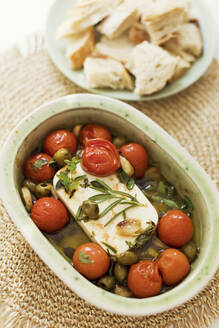 Baked feta cheese with olives, cherry tomatoes and herbs - ONAF00610