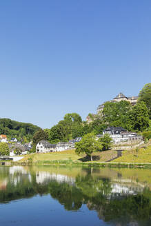 Germany, North Rhine Westphalia, Blankenheim, Schwanenweiher lake with town in background - GWF07862