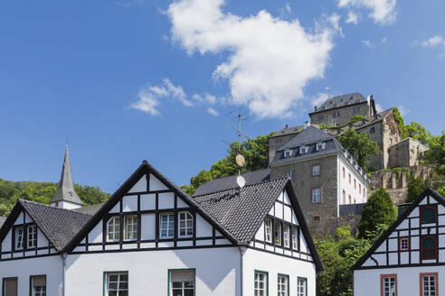 Germany, North Rhine Westphalia, Blankenheim, Half-timbered houses with Blankenheim Castle in background - GWF07868