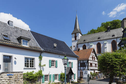 Germany, North Rhine Westphalia, Blankenheim, Historic houses in front of St. Maria Himmelfahrt church - GWF07871