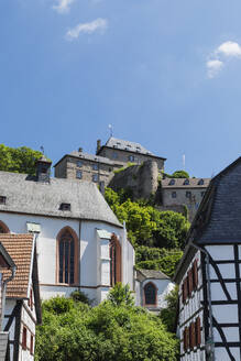 Germany, North Rhine Westphalia, Blankenheim, Half-timbered houses with Blankenheim Castle in background - GWF07872