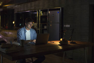 Junger Freiberufler arbeitet am Laptop im Home Office - IKF01007
